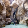 Dana under a huge boulder in Mujib Canyon